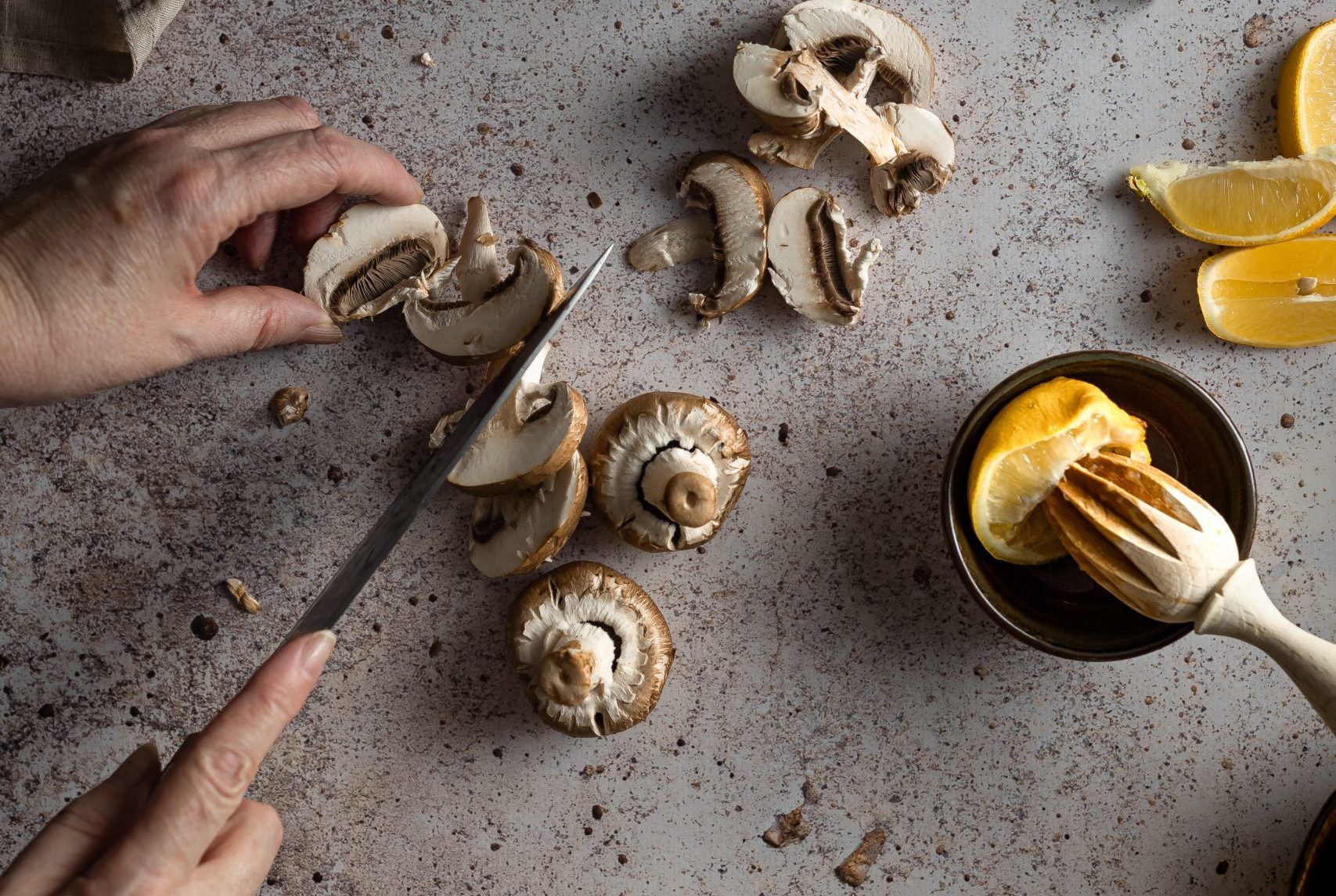 person holding stainless steel spoon with sliced lemon